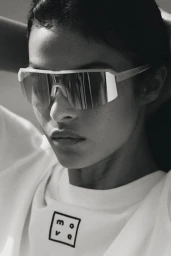 Close-up monochrome portrait of a model wearing wraparound sports sunglasses and a white t-shirt for H and M Move