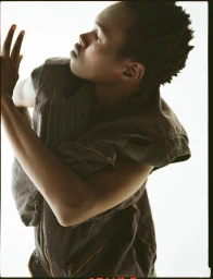 Model in dark sleeveless vest posing against a bright white background for Dapper Dan Magazine editorial photography