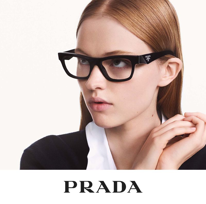 Close-up of a light-skinned woman wearing black Prada glasses, showcasing fashion eyewear and beauty aesthetics against a white backdrop.