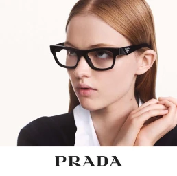 Model wearing thick black Prada eyeglasses against a plain white background in an eyewear campaign portrait