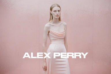 Model wearing a pink two-piece dress against a matching pink textured background with brand text overlay