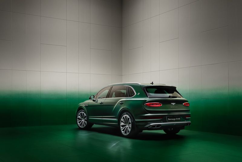 Rear view of a dark green Bentley Bentayga SUV in a photo studio, featuring detailed rims and a modern automotive design.