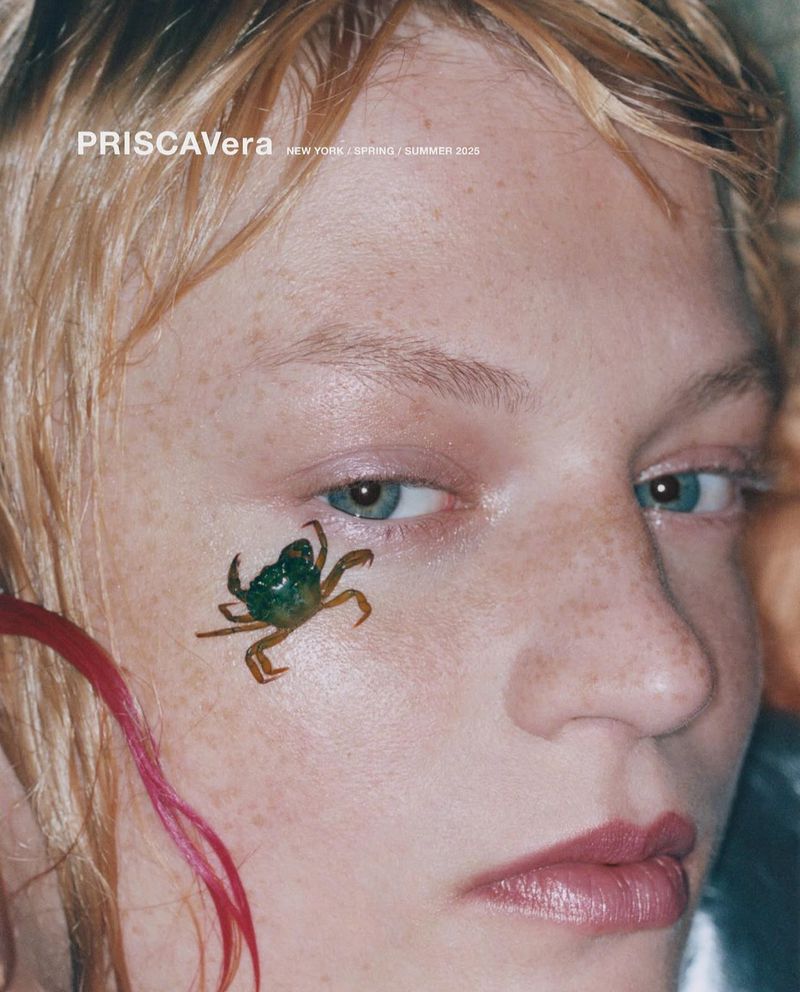 Close-up of a model's face in a fashion editorial, featuring a crab sticker on her cheek, with a PRISCAVERA logo visible.