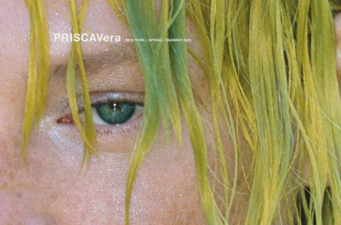 Close-up of a person's face with vibrant green and yellow-toned hair, focusing on their captivating green eye and complexion details.