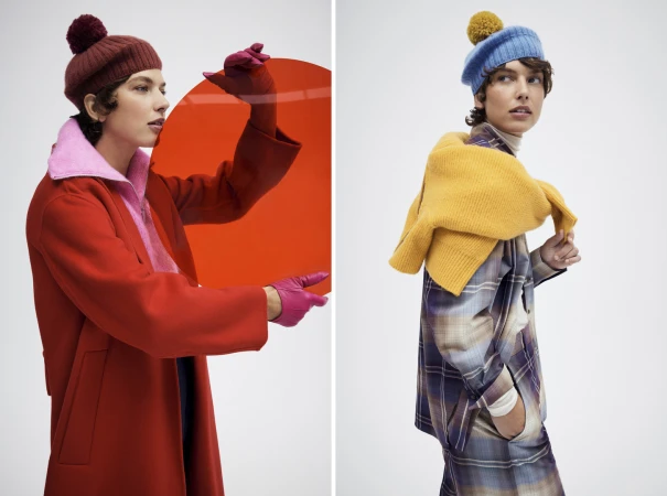 Two fashion models showcase autumn knitwear and outerwear in a studio setting with bright, solid-colored accents and a modern aesthetic.