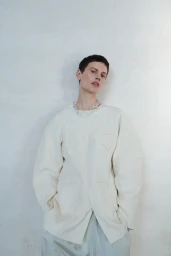 Model wearing a cream textured jacket and clear necklace against a white background for Cordera SS25 campaign