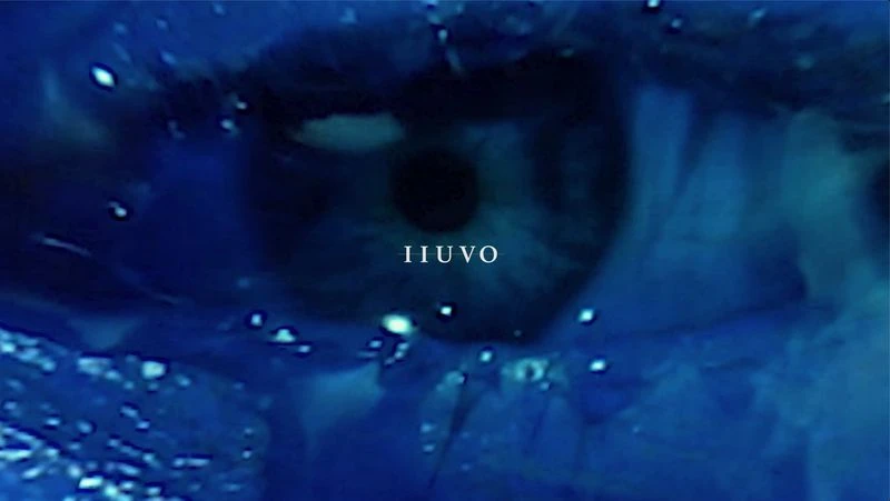 Macro close-up of a human eye with blue hues and the brand name IIUVO visible, creating a captivating and surreal visual experience.