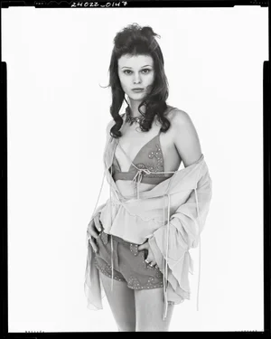 Model in layered bra top and shorts with sheer sleeves posing against white seamless background for Zara Studio S/S 2025 Campaign