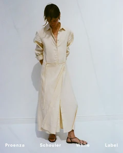 Model standing against a plain white background wearing a long cream button-down dress and black sandals for Proenza Schouler.