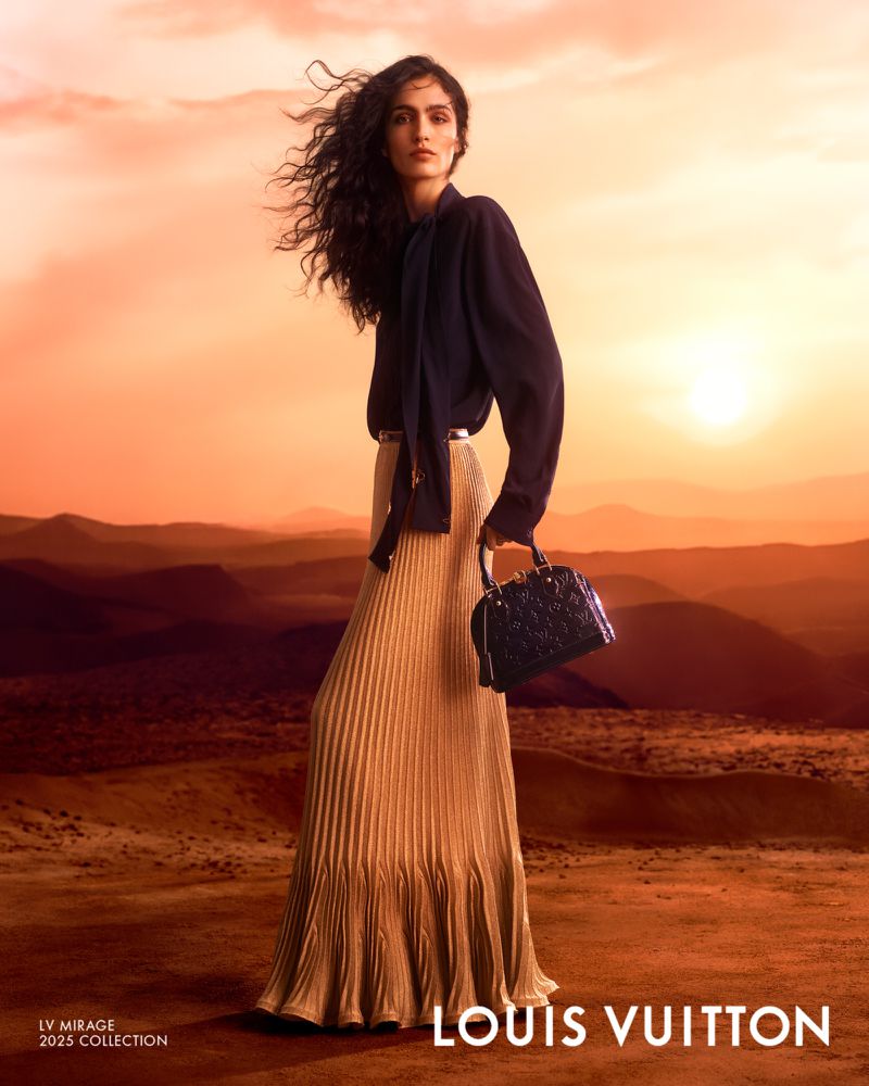Elegant woman poses in a Louis Vuitton ad wearing a gold pleated skirt and holding a black purse against a desert sunset backdrop.