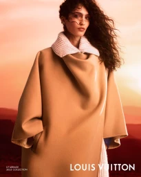 Model Sara Caballero in a camel coat with a white collar against a sunset sky for Louis Vuitton