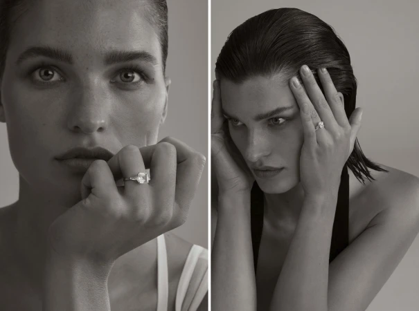 Monochrome portrait of a woman showcasing an engagement ring, eyes gazing to the side, in a minimalist studio setting with soft lighting.