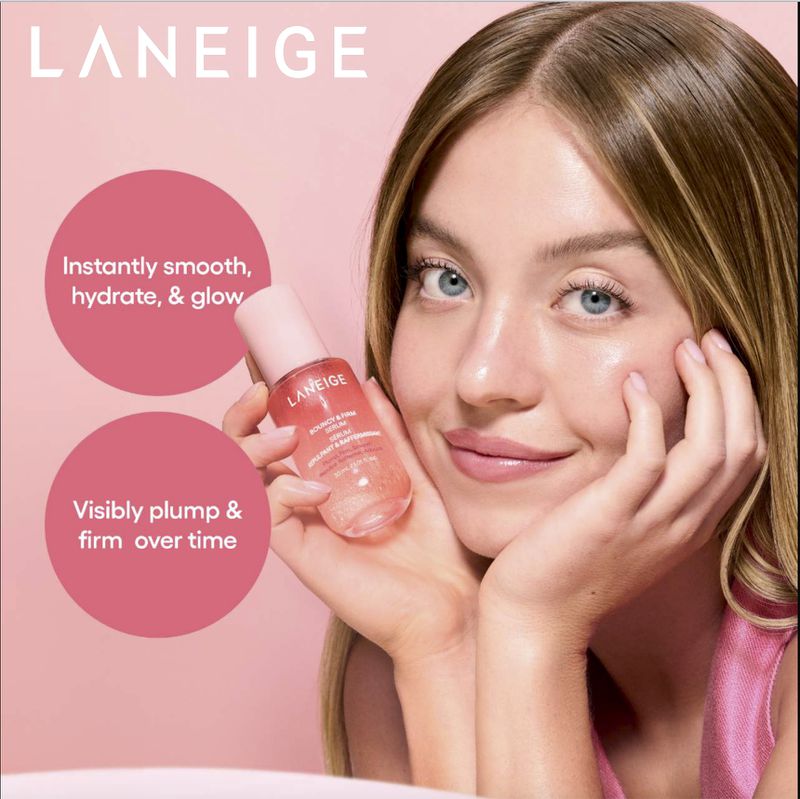 Close-up shot of a woman holding Laneige serum. Her skin is clear and radiant, on a pink background with product details.