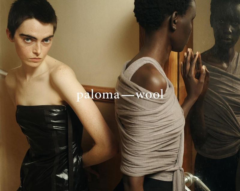 Two women are posing indoors, one in a black strapless dress and the other in a draped grey top, with the brand "paloma wool" visible.