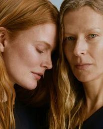 Close-up portrait of two female models with long red hair posing together for Comma International Women's Day campaign