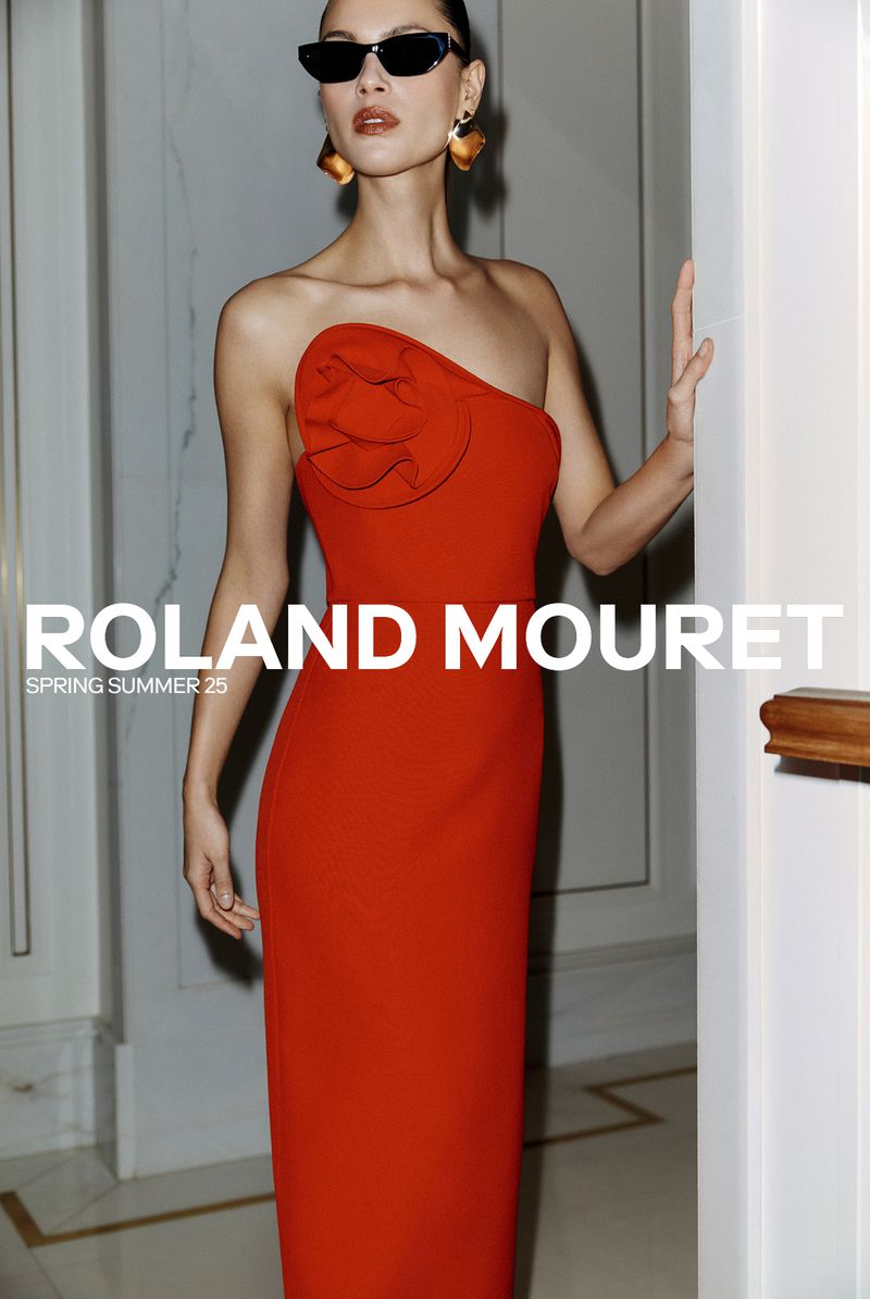Fashion editorial shot of a woman in a red evening gown with sunglasses and statement earrings, posing against a neutral background.