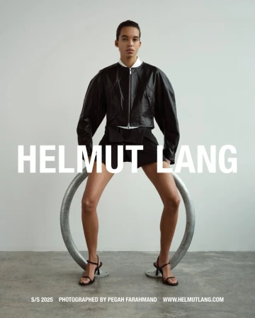 Fashion shot of a stylish adult posing indoors with a modern ring prop wearing a leather jacket, shorts, and high-heel shoes.