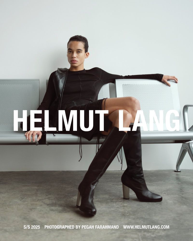 Model seated on a metal bench wearing a black long-sleeve top and tall boots for Helmut Lang Spring/Summer 2025