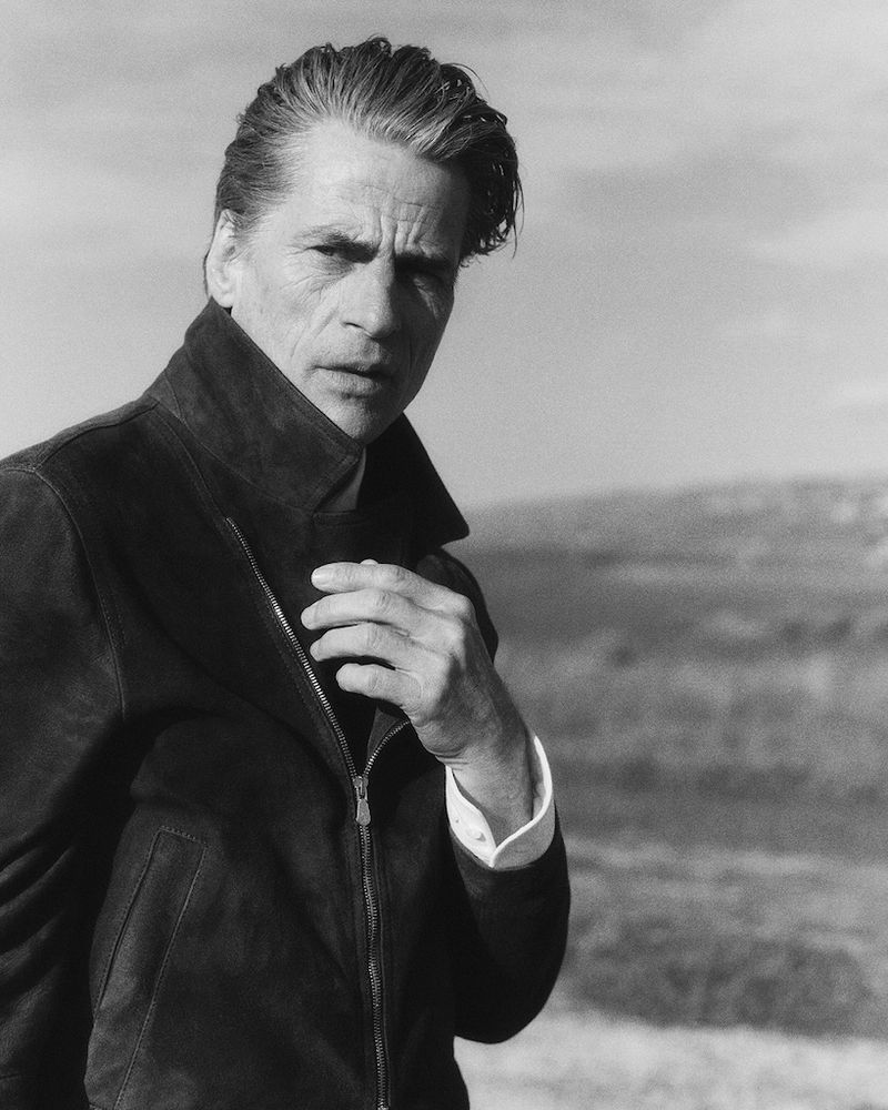 Mark Vanderloo wearing a dark zip-up jacket in a black-and-white outdoor portrait for Brunello Cucinelli SS25
