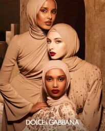Three female models in matching beige hijabs and earth-toned garments posing together for Dolce and Gabbana Beauty.