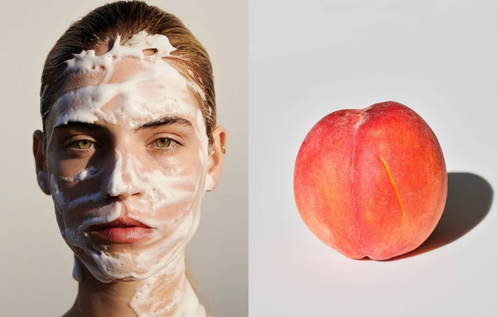 Close-up shot of a woman with a white facial mask and a peach against a white backdrop, suitable for beauty and skincare campaigns.
