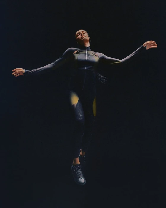 Model in form-fitting performance apparel leaping against a dark background for lululemon
