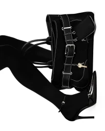 A black handbag with white contrast stitching placed next to a leg in a black stocking and high heel shoe.