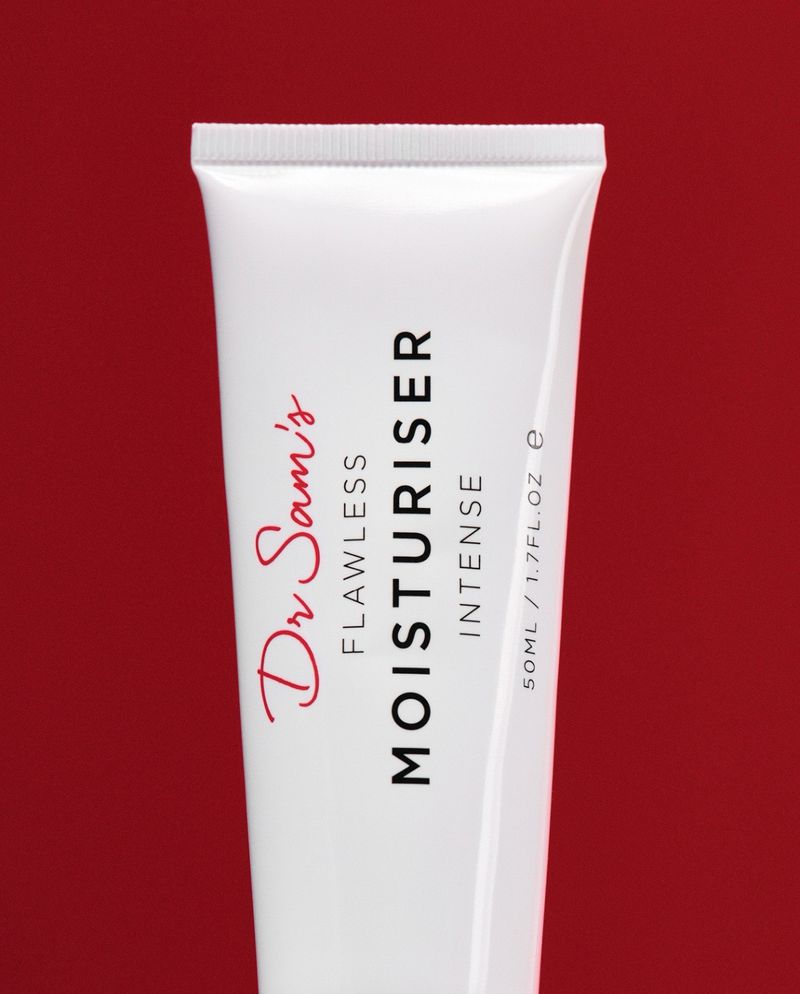 Close-up of a tube of Dr. Sam's Flawless Moisturiser Intense against a solid red background, highlighting beauty and skincare.