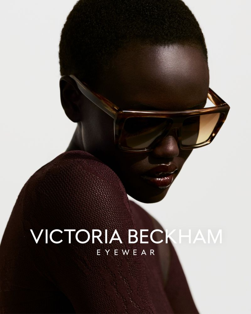 Portrait of a Black female model wearing large brown sunglasses, shot in a photo studio with soft lighting and a minimalist background.