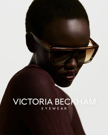 Portrait of a Black female model wearing large brown sunglasses, shot in a photo studio with soft lighting and a minimalist background.