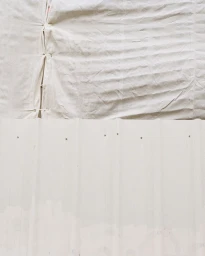 Textured white fabric draped above a corrugated metal surface with visible fastening rivets