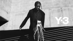 Man wearing a black blazer with fringed details standing against a concrete background for Y-3 S/S 2025 campaign.