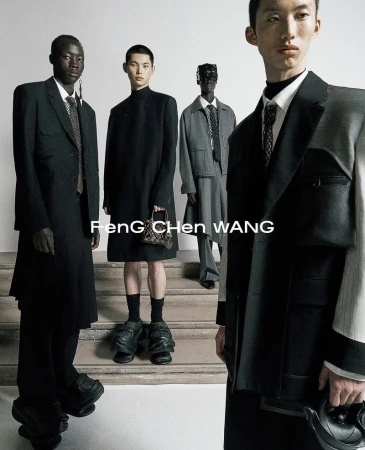 Four male models in dark tailored suits and coats posing on stone steps for Feng Chen Wang S/S 2025 campaign.