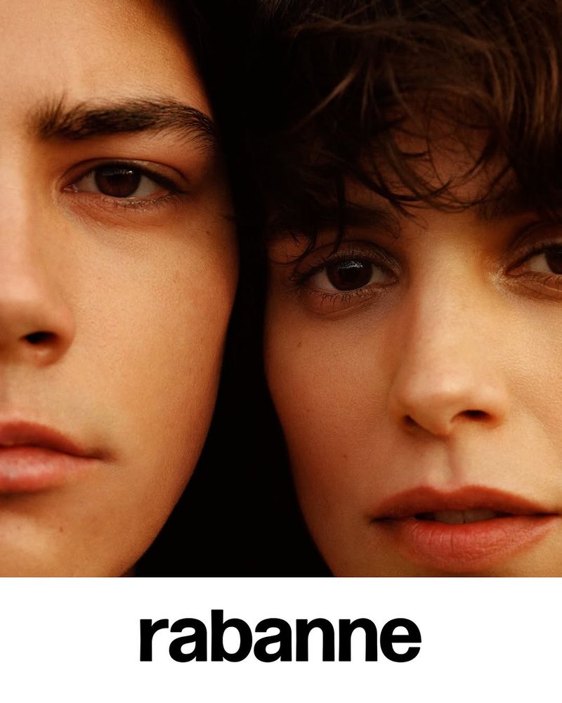 Close-up studio shot of a couple posing together in a fashion advertisement with the brand 'rabanne' visible at the bottom.