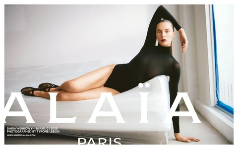 Model Daria Werbowy reclining on a white wrapped sofa wearing a black bodysuit for Alaïa campaign