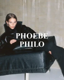Model Rebecca Leigh Longendyke in black leather coat seated on a black leather armchair for Phoebe Philo