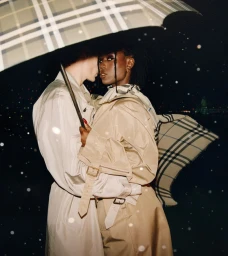 Jodie Turner-Smith standing close to a person under a check umbrella in the rain for the Burberry London in Love campaign