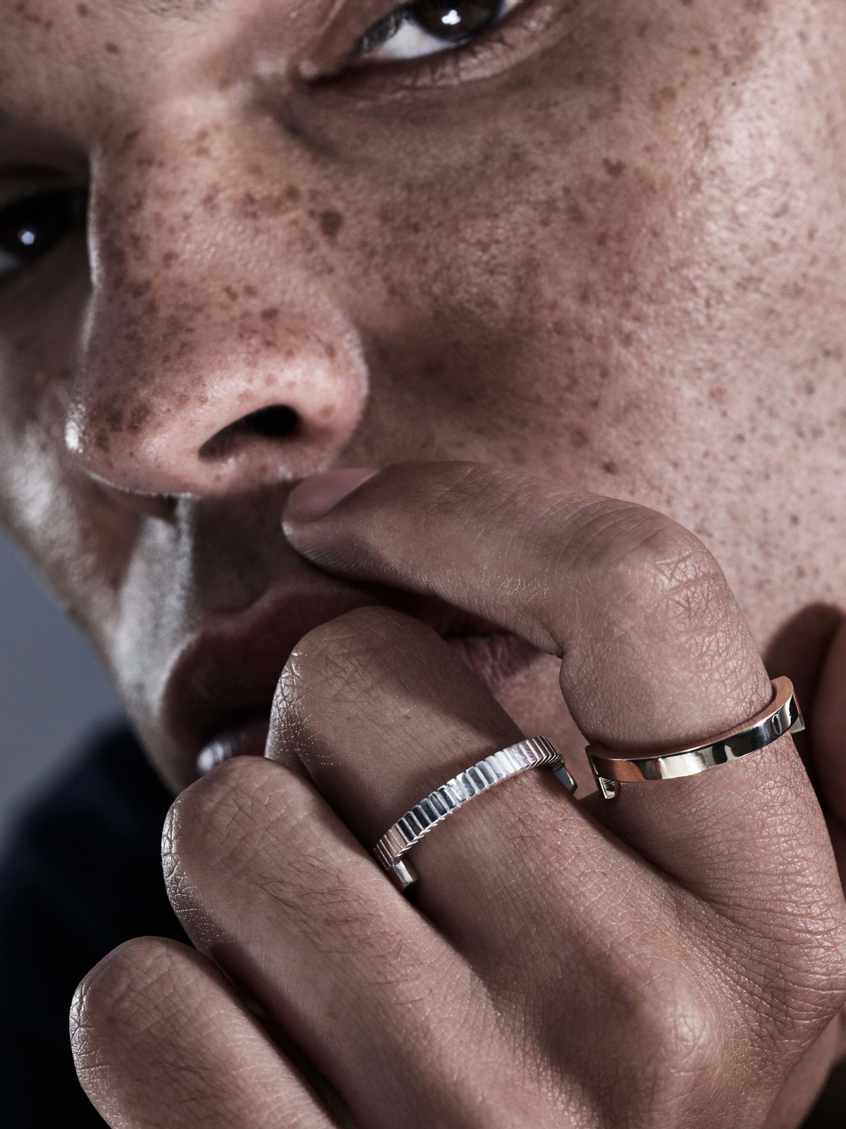 Close-up portrait of a man wearing two rings on his fingers near his face for Sarah & Sebastian