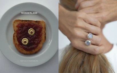 Close-up of jewellery displayed on a slice of toast with jam on a white plate alongside hands holding hair