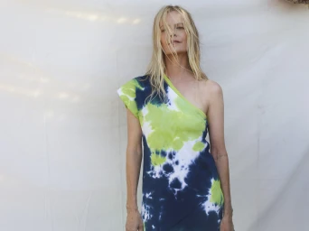 Woman in an asymmetric lime green and navy tie-dye dress against a plain white backdrop for Bassike Resort 24
