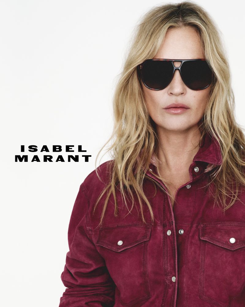 Fashion portrait of a blonde adult female model wearing sunglasses and a button-down shirt with the Isabel Marant logo.