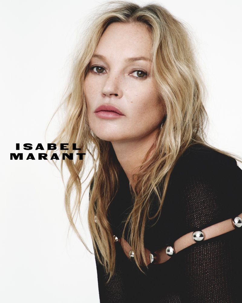 Close-up studio portrait of a blonde adult female in a black sweater, with the brand name Isabel Marant displayed on the left.