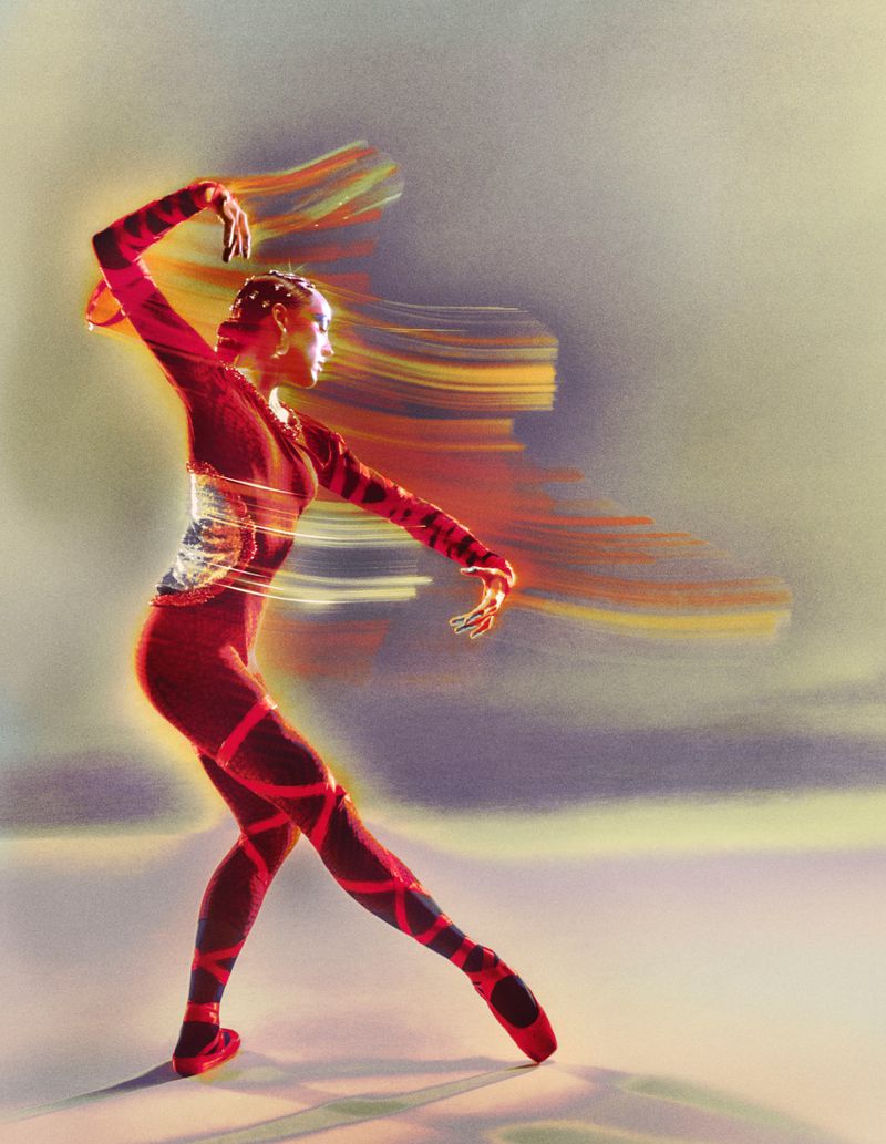 A slender figure in red ballet attire strikes a dynamic pose against a soft backdrop, creating an elegant blend of motion and grace.