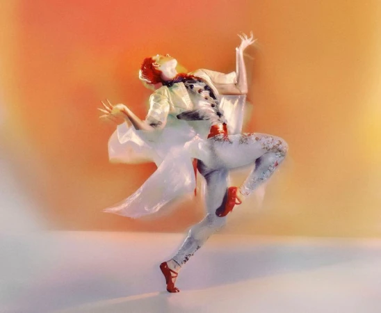 Artistic motion shot of a redhead woman in ballet pose with red shoes, floral leggings, and a white top against orange background.
