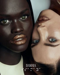 Close-up portrait of two female models with metallic gold lipstick against a neutral background for ISAMAYA Spring 2025.