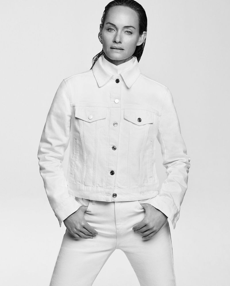 Amber Valletta wearing a white denim jacket in a portrait for the Karl Lagerfeld S/S 2025 campaign against a white backdrop.