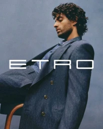 Man wearing a blue patterned blazer against a textured grey background for the Etro S/S 2025 campaign.