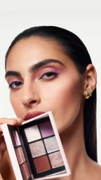 Model holding an open eyeshadow palette showcasing purple and metallic shades for Nars Cosmetics Spring 2025 campaign
