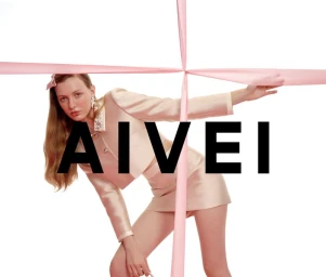 Model in pink skirt suit posing behind pink ribbon straps against white background with AIVEI text