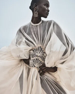 Model Abény Nhial wearing a sheer cream gown with statement earrings in the Zimmermann S/S 2025 campaign photographed by Benny Horne.